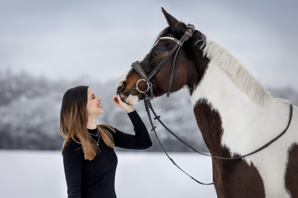 Frau mit Pferd bei Schneefotoshooting im Winter mit Coralie Duda Fotografie im Wetteraukreis